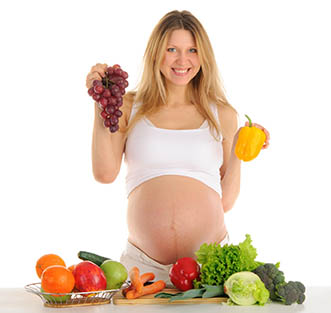 Happy pregnant woman with fruits and vegetables